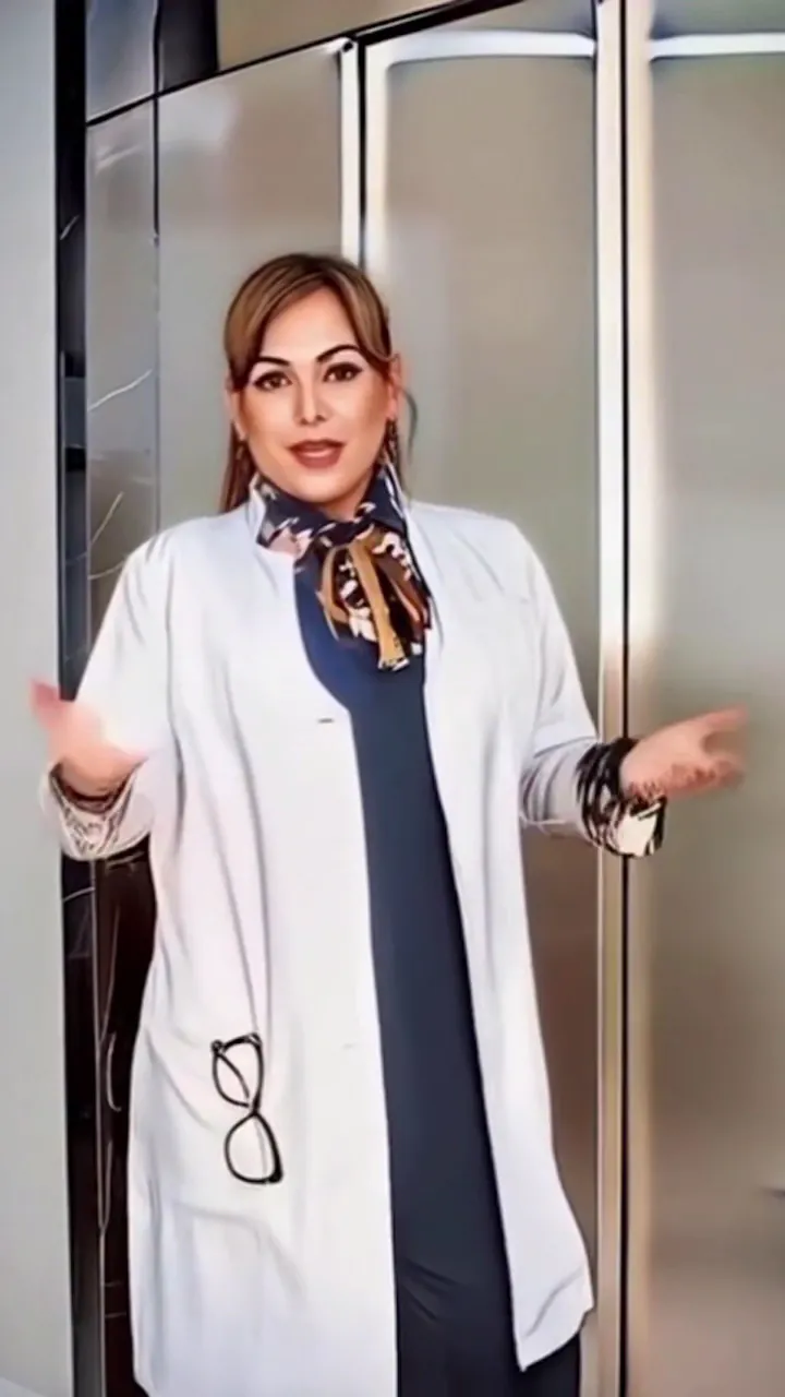 Adriane Galdino Henriques de jaleco branco e lenço estampado, de braços abertos em gesto de boas-vindas